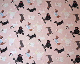 May include: Pale pink fabric featuring a repeating pattern of different dog breeds. The dogs include black poodles with red bows, dachshunds, white poodles, and small dogs with red bows. Some dachshunds wear blue and white striped tops.