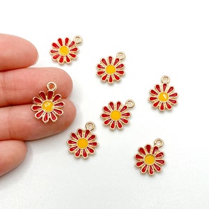 May include: Seven gold-colored metal charms shaped like red and yellow daisies. Each charm has a small loop at the top for attaching to jewelry or other crafts.