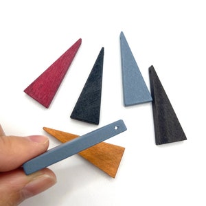May include: Six wooden triangle shapes in various colors, including red, blue, black, and brown. The triangles have a hole drilled through the top.
