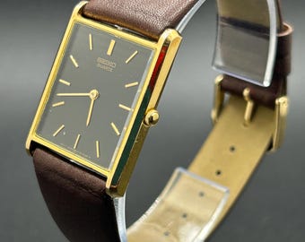 Reloj de cuarzo vintage Seiko 5Y30-5069 con caja rectangular dorada y esfera negra para hombre.