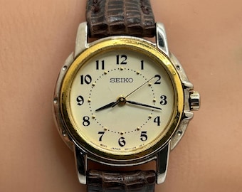 Reloj de cuarzo Seiko vintage para mujer, bicolor, bisel dorado, caja plateada, modelo 1N01-0J09