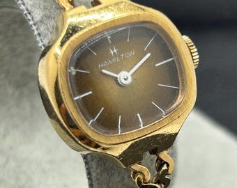 Reloj mecánico de mujer Hamilton vintage con caja tipo cojín dorada y esfera degradada marrón.