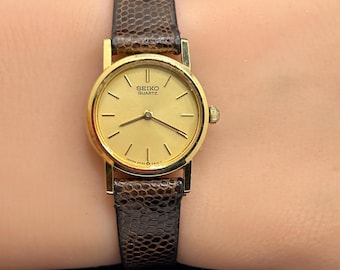 Reloj de cuarzo vintage Seiko 2P20-0A10 con esfera minimalista dorada para mujer