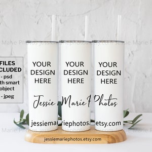 May include: Three white stainless steel tumblers with black lids and straws. The tumblers are on a wooden surface and have the text "YOUR DESIGN HERE" on each one. The text "Jessie Marie Photos" is also on the tumblers. The text "FILES INCLUDED - psd with smart object - jpeg" is on the left side of the image.