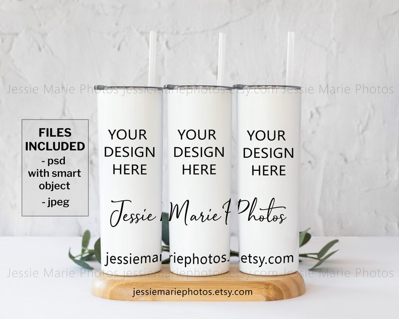 May include: Three white stainless steel tumblers with black lids and straws. The tumblers are on a wooden surface and have the text "YOUR DESIGN HERE" on each one. The text "Jessie Marie Photos" is also on the tumblers. The text "FILES INCLUDED - psd with smart object - jpeg" is on the left side of the image.
