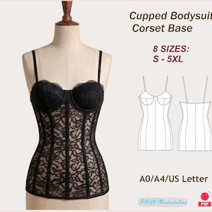 Puede incluir: Una taza de cerámica blanca con un asa negra y el texto "But First, Coffee" en negrita negra. La taza está sobre un fondo borroso. La taza mide aproximadamente 10 cm de altura.