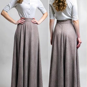 May include: A white button-down shirt with a brown and white patterned maxi skirt. The skirt has a high waist and a full, flowing silhouette.
