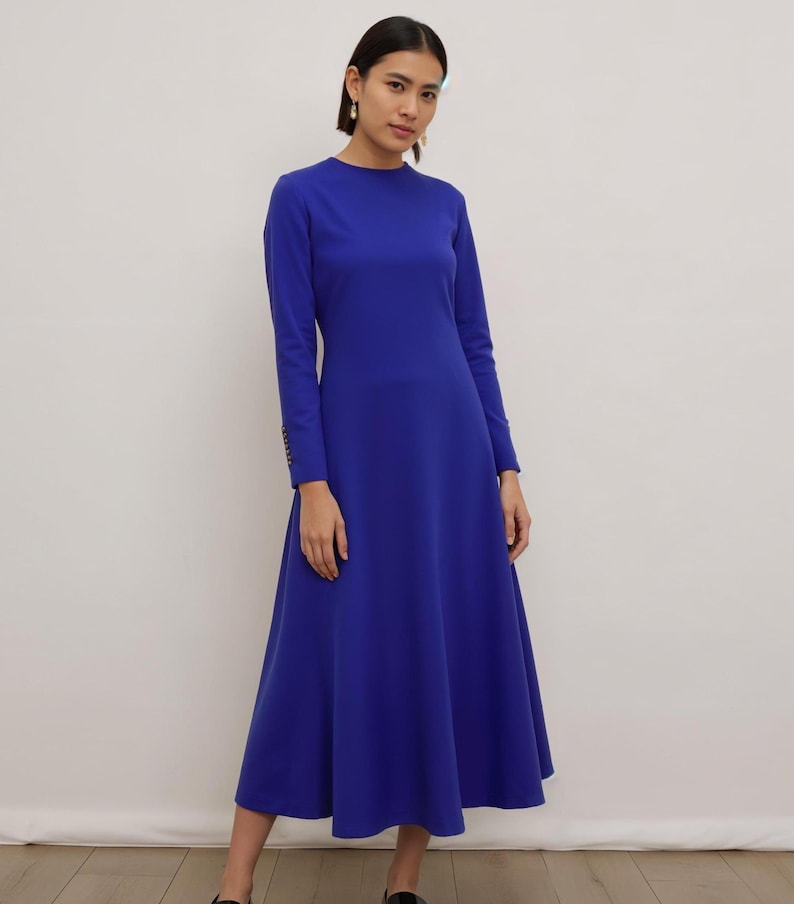 May include: A royal blue midi dress with long sleeves and a round neckline. The dress has a fitted bodice and a flared skirt.
