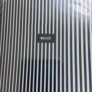 May include: A sheet of black and white nail art stickers with a repeating vertical stripe pattern. The sticker sheet has the code WG430 printed on it.