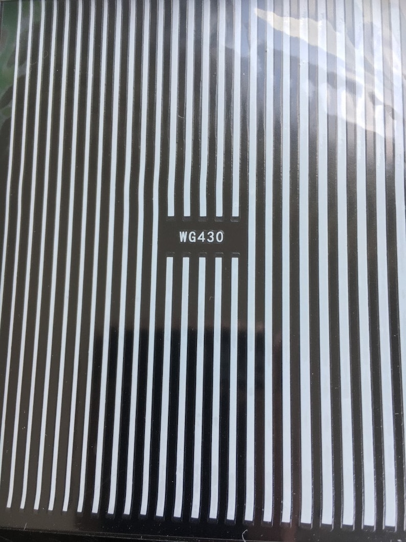 May include: A sheet of black and white nail art stickers with a repeating vertical stripe pattern. The sticker sheet has the code WG430 printed on it.