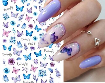 May include: A sheet of nail art stickers with a white background and a variety of blue and purple butterflies, flowers, and leaves. The text "Butterfly" and "F678" are printed on the sheet.