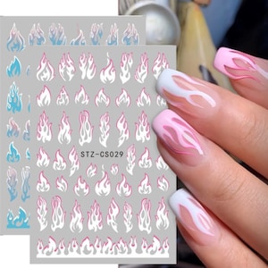 May include: Nail art stickers featuring a white and pink flame design. The stickers are on a sheet with the text "STZ-CS029".