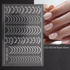 May include: Nail art stickers with a rose silver finish. The sheet includes a variety of designs, including curved lines and floral wreaths with the text "Believe in yourself" repeated. The sheet is labeled "STZ-GS104 Rose Silver".