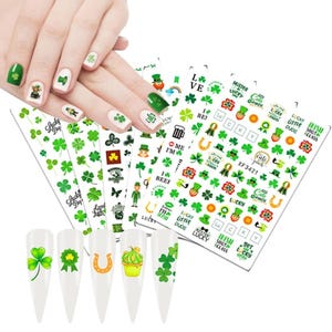 May include: Nail art stickers with St. Patrick's Day themes. The stickers feature green shamrocks, leprechauns, horseshoes, and text. Some nails are painted green and white with shamrock designs. The stickers are on a white background.