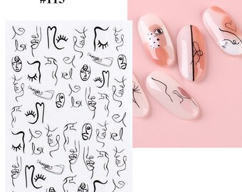 May include: Nail art stickers featuring abstract line art faces and minimalist designs. The sheet includes various black line drawings of faces, eyes, and abstract shapes. Several nails are painted with nude and peach tones, adorned with similar line art.