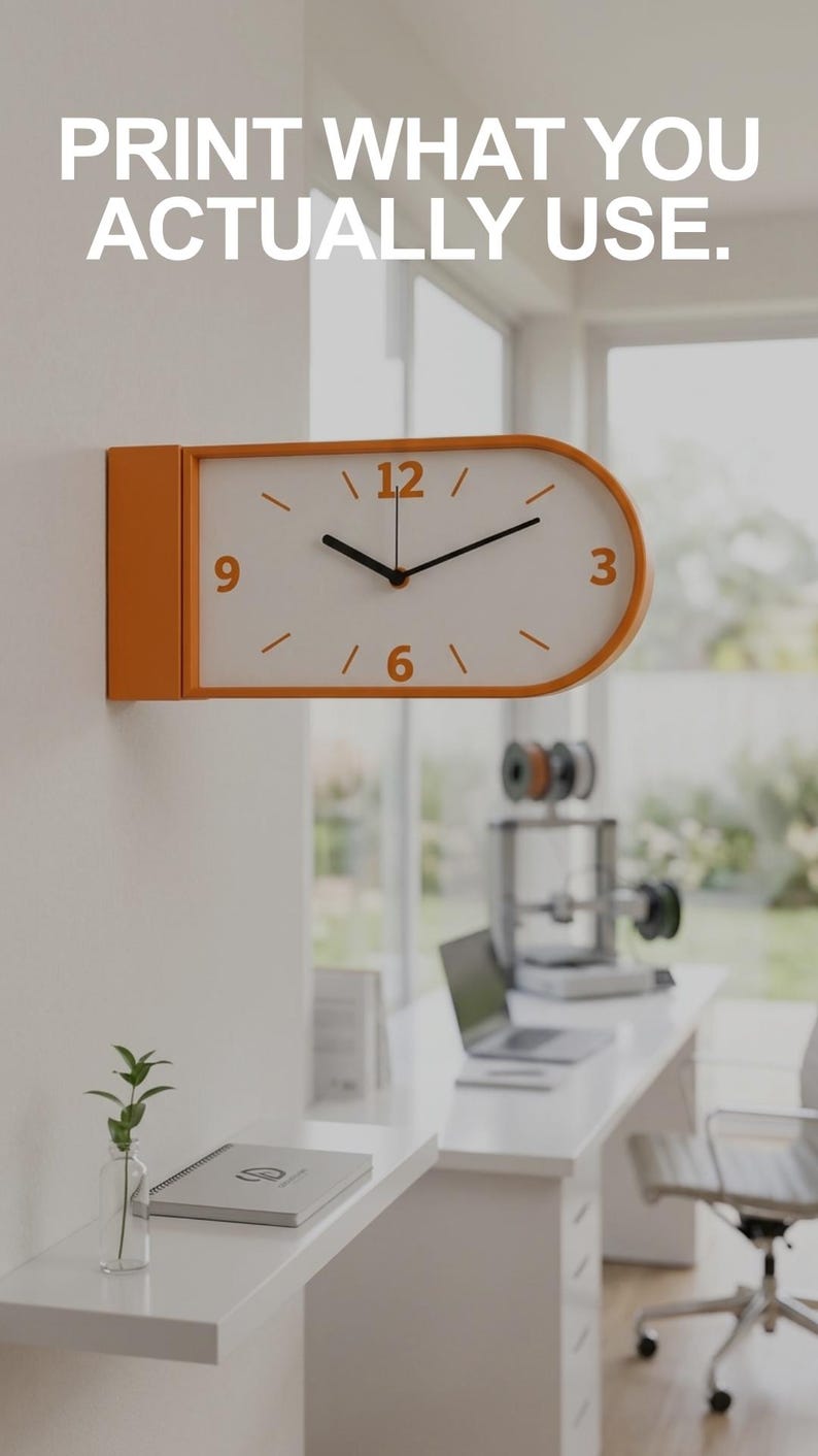 May include: Orange and white wall clock with black hands, mounted on a white wall. The clock has an oval face with orange numerals and markers. The text "PRINT WHAT YOU ACTUALLY USE" is above the clock. The clock is in a modern office setting.