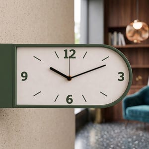 May include: A modern, olive green wall clock with a white face. The clock has black hands and numerals at 3, 6, 9, and 12. The clock is mounted on a textured beige wall. The time displayed is approximately 10:09.