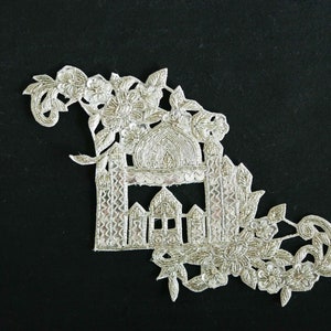 May include: Silver embroidered applique featuring a detailed design of a mosque with a dome and minarets, surrounded by floral motifs.