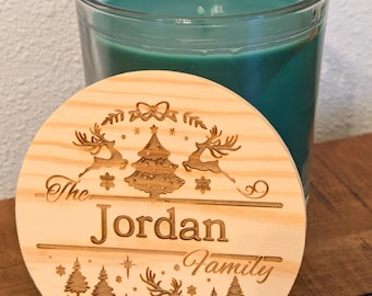 Könnte beinhalten: Ein runder Holzdeckel für eine Kerze mit einem Weihnachtsmotiv. Der Deckel ist mit dem Text "The Jordan Family" graviert und zeigt einen Weihnachtsbaum, Rentiere und Schneeflocken.