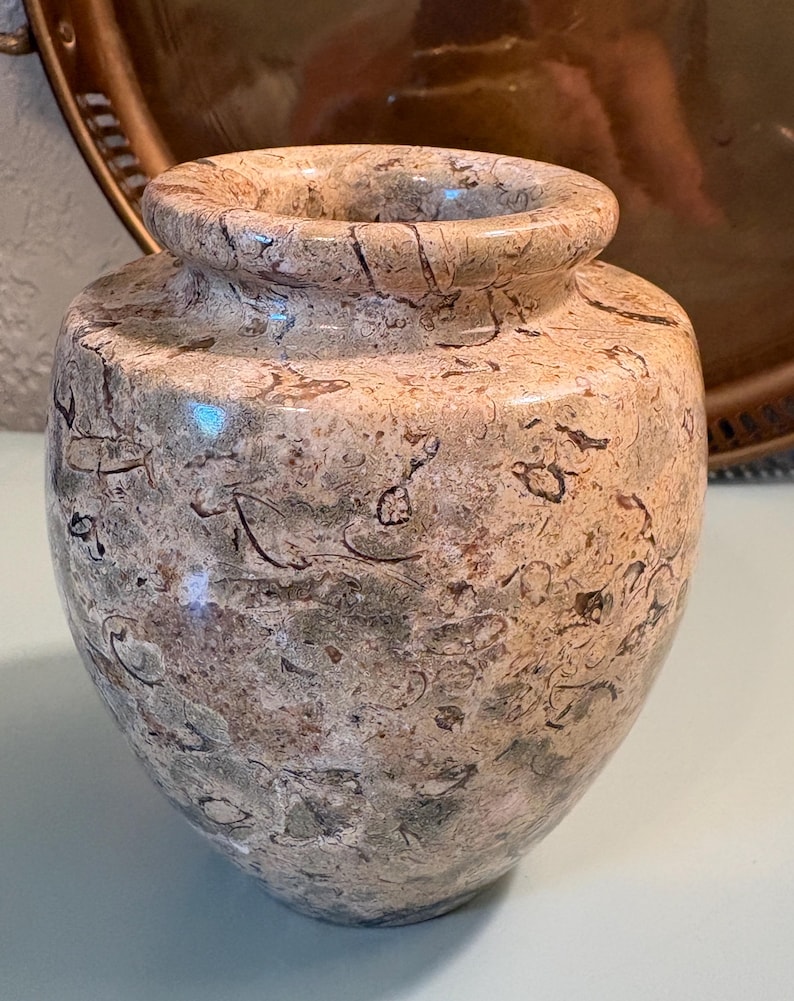 Puede incluir: Un jarr&oacute;n decorativo moteado con un cuerpo ancho y un cuello estrecho. El jarr&oacute;n tiene un color base marr&oacute;n claro con vetas marrones oscuras y verdes. El borde del jarr&oacute;n es liso y redondeado.