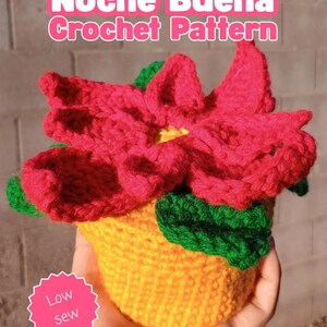 May include: A crocheted Noche Buena flower in a yellow pot with red petals, green leaves, and a yellow center. The text Noche Buena Crochet Pattern is at the top, and a pink starburst shape with the text Low sew is on the bottom left.