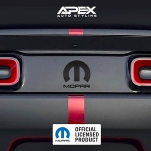 Puede incluir: Logotipo y texto Mopar negros en el panel trasero de un coche, con detalles en rojo y negro. La imagen también incluye el texto "OFFICIAL LICENSED PRODUCT" y el logotipo de Apex Auto Styling.