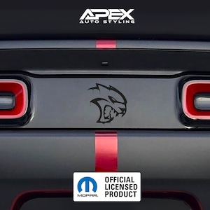Może przedstawiać: Tył czarnego samochodu z czerwonymi akcentami i czarnym logo Hellcat. Obraz zawiera tekst "APEX AUTO STYLING" oraz logo Mopar z napisem "OFFICIAL LICENSED PRODUCT".