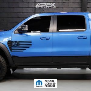Puede incluir: Una camioneta azul con un gráfico en blanco y negro de una bandera con un diseño de calavera y huesos cruzados en el lateral. La camioneta tiene ruedas y molduras negras. El texto "Apex Auto Styling" está en la parte superior.