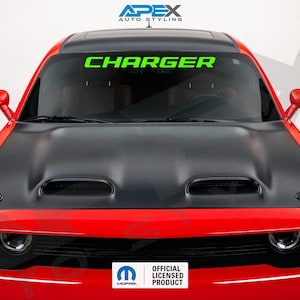 May include: A red Dodge Charger with a black hood and a green "CHARGER" windshield banner. The car has a sleek design with a black hood and a red body. The image also includes the "Apex Auto Styling" logo and an "Official Licensed Product" badge.