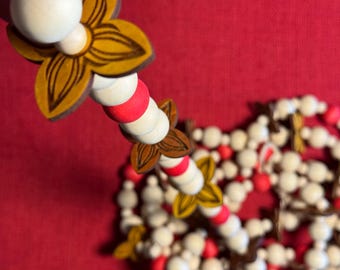 Polynesian inspired wood beaded garland with hand dyed beads and laser cut tropical flowers.