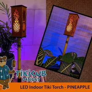 May include: An LED indoor tiki torch with a pineapple design. The rectangular wooden lamp has a pineapple cutout on the front and back, and is mounted on a bamboo pole. The text "LED Indoor Tiki Torch - PINEAPPLE" is at the bottom.