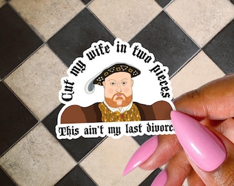 May include: A sticker featuring a cartoon illustration of King Henry VIII with the text "Cut my wife in two pieces" and "This ain't my last divorce." The sticker is held by a hand with pink nails.