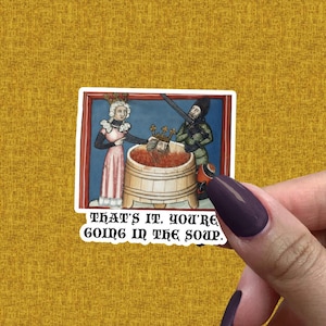 May include: A sticker featuring a medieval-style illustration with the text "THAT'S IT, YOU'RE GOING IN THE SOUP." The image depicts a person in a crown being dunked into a wooden barrel of red liquid by two other figures. The background is blue.