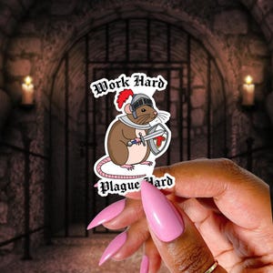 May include: A sticker featuring a cartoon rat in knight's armor, holding a sword and shield. The text "Work Hard" and "Plague Hard" are above and below the rat. The background is a medieval castle.