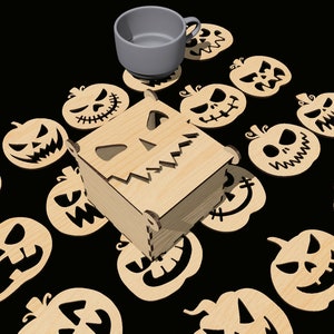 May include: A wooden box with a carved pumpkin face design, surrounded by 14 smaller wooden pumpkin cutouts with various facial expressions. The box is sitting on a black surface.