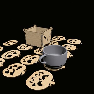 May include: A set of 10 wooden pumpkin-shaped coasters with a spooky face design. The coasters are arranged around a gray ceramic mug and a wooden box with a pumpkin face design.