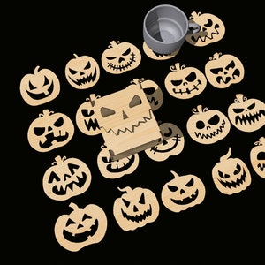 May include: A set of 16 wooden pumpkin coasters with carved jack-o'-lantern faces. The coasters are arranged in a circle around a wooden box with a carved jack-o'-lantern face. A gray mug is sitting on top of one of the coasters.