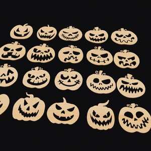 May include: Twenty wooden pumpkin cutouts with various carved faces. The pumpkins are beige and have black carved features.
