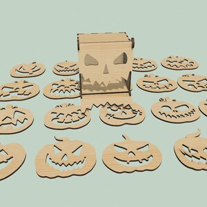 May include: A wooden box with a carved pumpkin face and 15 wooden pumpkin cutouts with carved faces. The box is open and the cutouts are scattered around it.