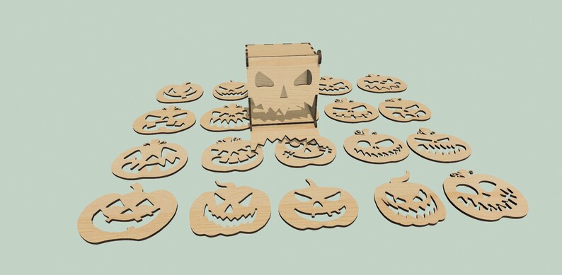 May include: A wooden box with a carved pumpkin face and 15 wooden pumpkin cutouts with carved faces. The box is open and the cutouts are scattered around it.