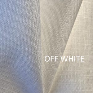 May include: A folded piece of off-white fabric with a visible woven texture. The material displays a consistent light colour throughout, and the text OFF WHITE is printed in a clean, sans-serif font on the lower right side of the fabric surface.