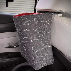 以下が含まれることがあります： グレーの布製車用ゴミ袋で、内側は赤色です。togetherness、peace、home、joy、family、heartという白い筆記体の文字がプリントされています。白いプラスチック製のクリップで車のヘッドレストに取り付けられています。