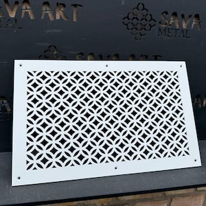 May include: A white metal decorative vent cover with a geometric pattern of interlocking circles. The vent cover is rectangular with rounded corners and has several screw holes. The background features the text "SAVA ART METAL".