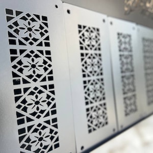 May include: A row of five silver metal panels with a decorative cut-out design. The design features a repeating pattern of geometric shapes and flowers.