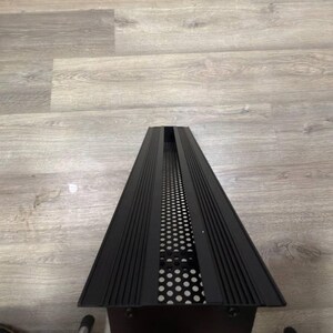 May include: Black metal vent cover with a grid pattern and a series of horizontal lines.