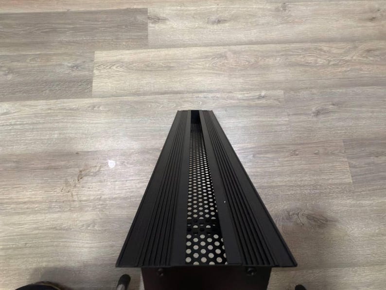 May include: Black metal vent cover with a grid pattern and a series of horizontal lines.