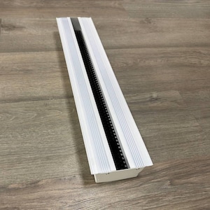 May include: White rectangular vent cover with a black grill insert. The vent cover has a slightly curved bottom edge.