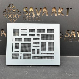 Puede incluir: Un panel decorativo de metal blanco con un patrón geométrico de cuadrados y rectángulos. El panel está hecho de metal y tiene una superficie ligeramente texturizada. El panel está etiquetado "SAVA ART METAL" en la esquina superior derecha.