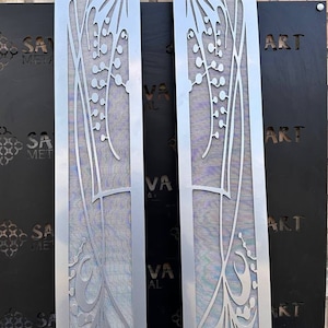 May include: Two silver metal panels featuring a decorative floral design. The panels are approximately 45 cm tall and 15 cm wide. The design incorporates a stylised lily of the valley flower with delicate leaves and stems. The panels are ideal for adding a touch of elegance to any room.