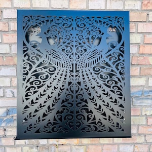 Puede incluir: Decoración de pared de metal negro con un diseño de corte por láser de dos pavos reales con plumas de cola intrincadas y patrones florales.